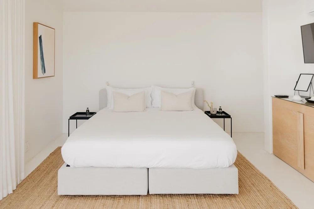 A white room with one picture on the wall and the morning coming through the curtain